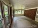 Bright sunroom with brick walls, large windows offering scenic views, and carpeted floors at 34393 Springdale Dr, New London, NC 28127