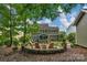 Large backyard featuring a firepit area, mature trees, lush landscaping, and a private outdoor retreat at 3701 Methodist Church Ln, Waxhaw, NC 28173