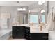Bathroom featuring black cabinets, double sinks, large mirrors, and a bathtub at 3701 Methodist Church Ln, Waxhaw, NC 28173