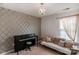 Cozy bonus room with a piano, window, sofa, accent wall and decorative pillows at 3701 Methodist Church Ln, Waxhaw, NC 28173