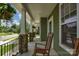 Relaxing covered front porch featuring classic columns, decorative railing, and a cozy rocking chair, perfect for enjoying the outdoors at 3701 Methodist Church Ln, Waxhaw, NC 28173