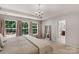 Spacious bedroom with large windows, chandelier, neutral tones, and en suite bath access at 3701 Methodist Church Ln, Waxhaw, NC 28173