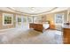 Spacious bedroom featuring a tray ceiling, carpet flooring, a ceiling fan, and doors leading to a private balcony at 3706 Song Sparrow Dr, Matthews, NC 28104