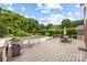Outdoor deck area with a grill, dining table, and view of the swimming pool and landscaped backyard at 3706 Song Sparrow Dr, Matthews, NC 28104