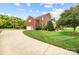 Side view of a brick home featuring a driveway and well-kept lawn at 3706 Song Sparrow Dr, Matthews, NC 28104