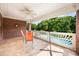 Covered patio with brick accents, offering views of the pool area and lush landscaping for outdoor relaxation at 3706 Song Sparrow Dr, Matthews, NC 28104