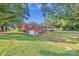 Backyard view of a brick home featuring a walkout basement and well maintained lawn at 37156 Southside Rd, Albemarle, NC 28001