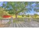 Backyard deck overlooking a lush green lawn with mature trees and distant red barn with country views at 37156 Southside Rd, Albemarle, NC 28001