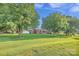 Expansive front yard with mature trees framing the charming one-story brick home at 37156 Southside Rd, Albemarle, NC 28001