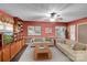 Digitally staged: Bright living room with comfortable seating, ceiling fan, and custom built-in shelving at 37156 Southside Rd, Albemarle, NC 28001