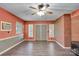 Cozy living room with wood-look floors, brick accent wall, ceiling fan, and natural light at 37156 Southside Rd, Albemarle, NC 28001