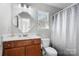 Cozy bathroom with a wood vanity, framed mirror, and shower with an updated curtain at 3735 Ernie Dr, Charlotte, NC 28269