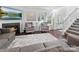 Living area with a fireplace, comfortable seating, and staircase visible from the open layout at 3735 Ernie Dr, Charlotte, NC 28269
