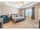 Comfortable main bedroom featuring a cozy chair, tray ceiling and large window at 385 Willow Tree Dr, Rock Hill, SC 29732