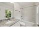 This bathroom features granite countertops, a modern sink, and a shower-tub combo with white tile at 443 Faith Sw Dr, Concord, NC 28027