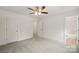 This bedroom boasts neutral walls and carpet, a ceiling fan, and an ensuite bathroom at 443 Faith Sw Dr, Concord, NC 28027