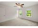 This bedroom boasts neutral walls and carpet, a ceiling fan, and two large windows for lots of light at 443 Faith Sw Dr, Concord, NC 28027