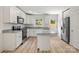 Well-lit kitchen with granite countertops, stainless steel appliances, and backyard access at 443 Faith Sw Dr, Concord, NC 28027