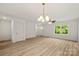 Sun-drenched living room with hardwood floors, modern lighting, and a view to the front entrance at 443 Faith Sw Dr, Concord, NC 28027