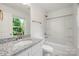 Bright bathroom featuring a granite countertop, white cabinets, and a shower-tub combo at 445 Faith Sw Dr, Concord, NC 28027