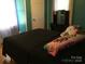 Bedroom with black bedspread and turquoise curtains, featuring a window and bed at 448 Belk St, Lancaster, SC 29720