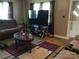 Living room with a large television, sofa, coffee table, and hardwood floors at 448 Belk St, Lancaster, SC 29720
