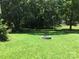 Expansive green yard with mature trees and a charming circular stone firepit at 448 Belk St, Lancaster, SC 29720