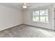 Neutral bedroom featuring carpeted floors, a ceiling fan, and a bright window for natural light at 5306 Lee Massey Rd, Waxhaw, NC 28173