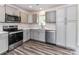 Modern kitchen featuring gray cabinets, stainless steel appliances, white countertops, and wood-look flooring, offering style and functionality at 5306 Lee Massey Rd, Waxhaw, NC 28173