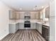 Well-lit kitchen showcasing gray cabinetry, stainless steel appliances, and sleek countertops, creating an inviting culinary space at 5306 Lee Massey Rd, Waxhaw, NC 28173