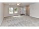 Bright living room with neutral carpet, ceiling fan and abundant natural light, creating a comfortable and welcoming environment at 5306 Lee Massey Rd, Waxhaw, NC 28173