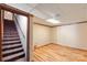 Spacious basement featuring laminate floors, wood trim, drop ceiling, and stair access to the floor above at 5563 Grace Chapel Rd, Hickory, NC 28601