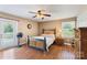 Comfortable bedroom featuring hardwood floors, ceiling fan, and natural light from a window and glass patio door at 5563 Grace Chapel Rd, Hickory, NC 28601