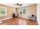 Bright bedroom featuring two windows, a ceiling fan, hardwood floors, and neutral walls at 5563 Grace Chapel Rd, Hickory, NC 28601