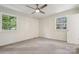 This bedroom features neutral carpet, two windows, and a modern ceiling fan at 613 Davis St, Lancaster, SC 29720
