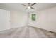 This bedroom has neutral carpet, a modern ceiling fan, and natural light from the window at 613 Davis St, Lancaster, SC 29720