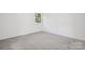 This bedroom boasts neutral carpet, a window offering natural light, and fresh white walls at 613 Davis St, Lancaster, SC 29720