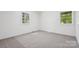 A bright bedroom with neutral carpet and two windows offers ample natural light at 613 Davis St, Lancaster, SC 29720