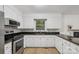 Bright kitchen with white cabinets, black countertops and stainless steel appliances at 613 Davis St, Lancaster, SC 29720