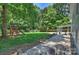 Expansive backyard with a play area, basketball hoop, patio, and lush landscaping at 6150 Rocky Falls Rd, Charlotte, NC 28211