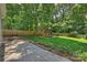 Landscaped backyard featuring a wooden play structure, and a comfortable patio seating area at 6150 Rocky Falls Rd, Charlotte, NC 28211