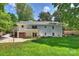 Large backyard featuring the white house and wooden garage with a basketball hoop and lush greenery at 6150 Rocky Falls Rd, Charlotte, NC 28211