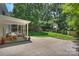 The backyard features lush lawn, a play structure, basketball hoop, and a partially covered patio space at 6150 Rocky Falls Rd, Charlotte, NC 28211