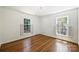 Well-lit bedroom with hardwood floors and two windows offering natural light at 6150 Rocky Falls Rd, Charlotte, NC 28211