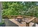 Outdoor wooden deck with seating, perfect for enjoying the surrounding green scenery at 6150 Rocky Falls Rd, Charlotte, NC 28211
