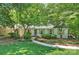 Charming one-story home with manicured lawn, inviting walkway, and mature trees providing ample shade at 6150 Rocky Falls Rd, Charlotte, NC 28211