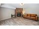 Spacious living room featuring a brick fireplace, wood-look flooring, and ample natural light at 6150 Rocky Falls Rd, Charlotte, NC 28211