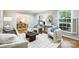 Cozy living room featuring plush seating, natural light, and seamless flow into the adjacent dining area at 6150 Rocky Falls Rd, Charlotte, NC 28211