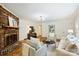 Bright living room featuring a brick fireplace, hardwood floors, and comfortable seating at 6150 Rocky Falls Rd, Charlotte, NC 28211