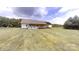 The home features a spacious yard with lush green grass and tree-lined border at 6825 Woodleaf Rd, Woodleaf, NC 27054